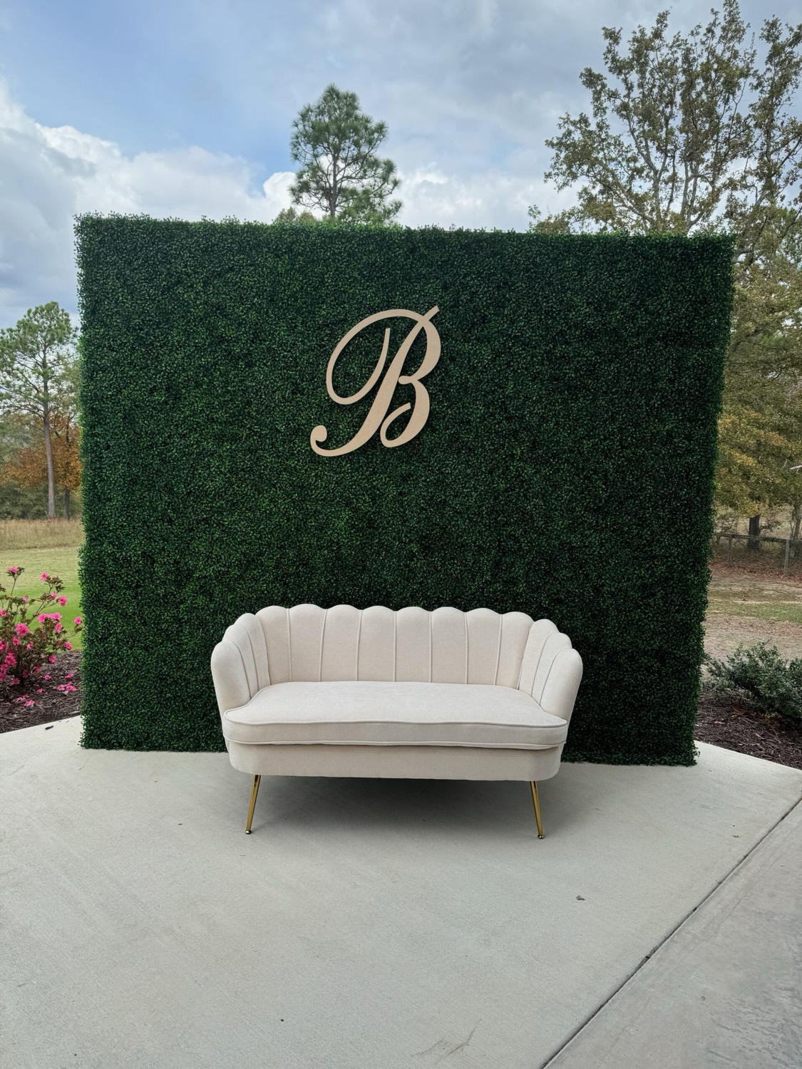 Lush greenery wall backdrop with a velvet settee